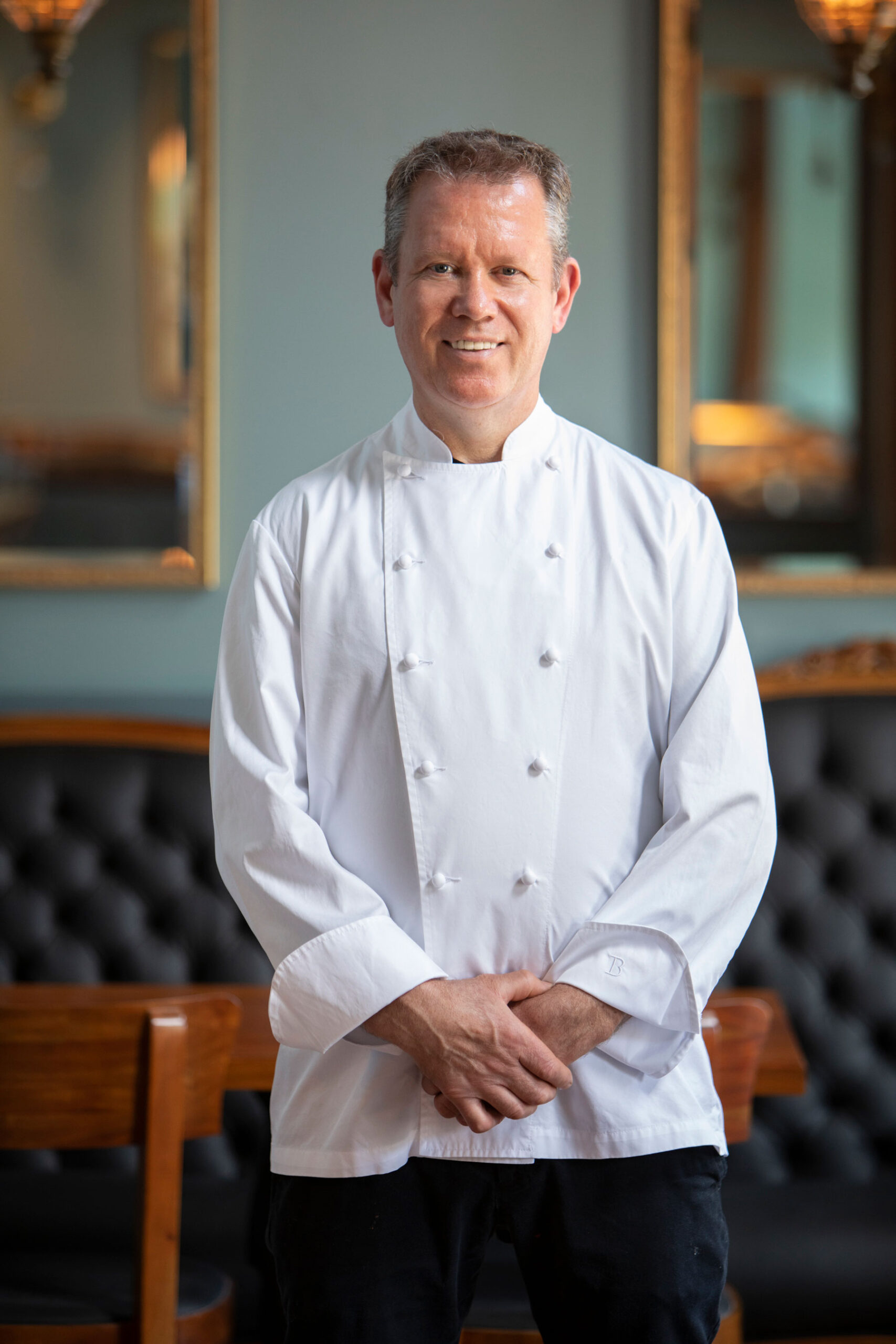 chef walter manzke in chef whites posing in the dining room