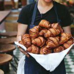chef margarita holding a tray full of croissants